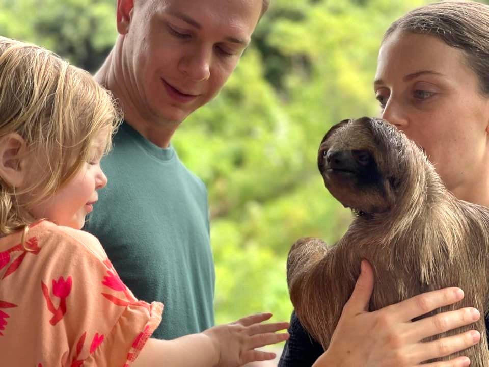 Child engaging with sloth at Mayan Eden Eco Park